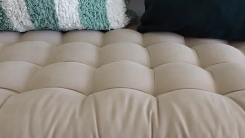 Close-up cinematic low angle shot of comfy cushioned ottoman with decorativ.. Stock-Footage 331934562