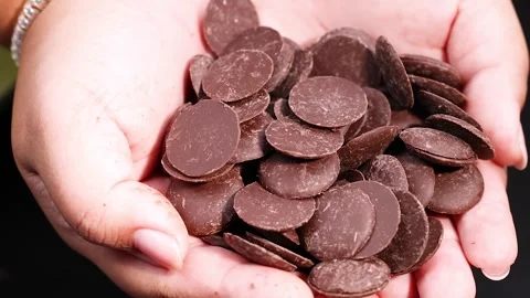 Close-up cinematic motion of hands holding delicious small round chocolate .. Video stock 332586414