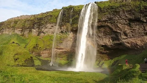 Close-up cinematic shot of falling water and rainbow at Seljalandsfoss Stock Footage 334766636