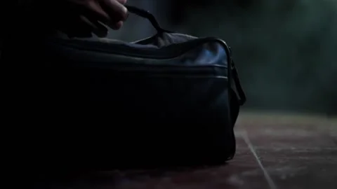 Close up cinematic shot of a hand passing a black colored bag, high resolution Stock Footage 160953559