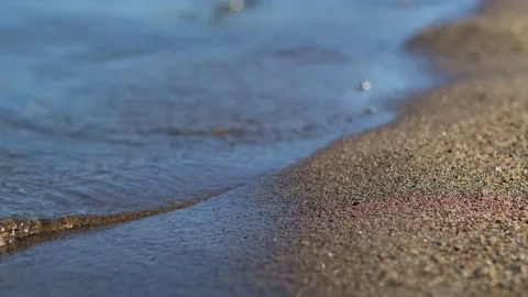 Close-up cinematic shot small waves on the sandy beach. Видео 255198969