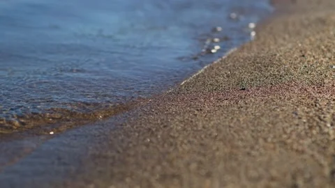 Close-up cinematic shot small waves on the sandy beach. Stock Footage 261365366