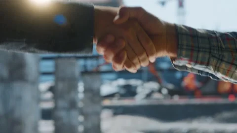 A close up cinematic shot of two men shaking hands on a construction site w.. Stock Footage 337411741