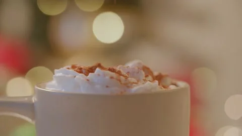 Close up of cinnamon being sprinkled on whipped cream, warm holiday drink 库存影片 220755662