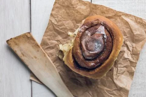 Close-up of a cinnamon roll over a white rustic wooden table Stock Photos
