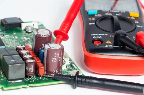 Close-up of a circuit board with electronic components and a multimeter with  Foto stock