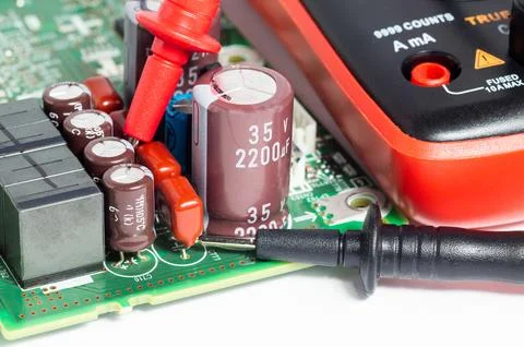 Close-up of a circuit board with electronic components and a multimeter with  Foto stock