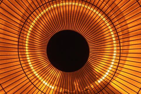 Close-up of circular orange light fixture with radiating lines and dark cente Stock Photos