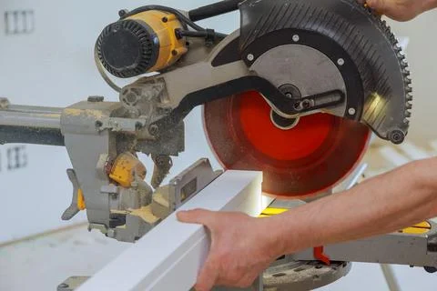 Close up of Circular saw cutting sharp rotary blade new baseboard woodwork Stock Photos