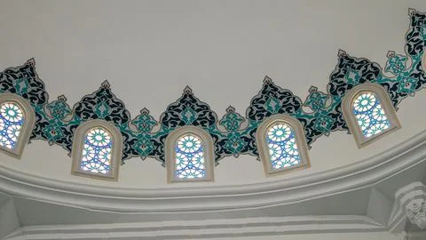 Close up of a circular wall plaque with Arabic script in a bright architect.. Stock Photos