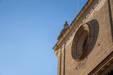 Close-up of a circular window on a historic building against a clear blue sky Foto stock