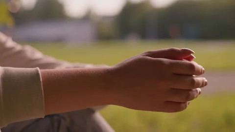 Close-Up of Clasped Hands Gently Rubbing Together in Calming Outdoor Greenery Stock Footage 293654938