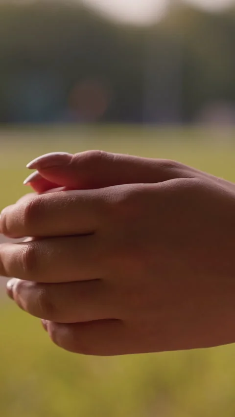 Close-Up of Clasped Hands Gently Rubbing Together in Calming Outdoor Greenery Stock Footage 310412486