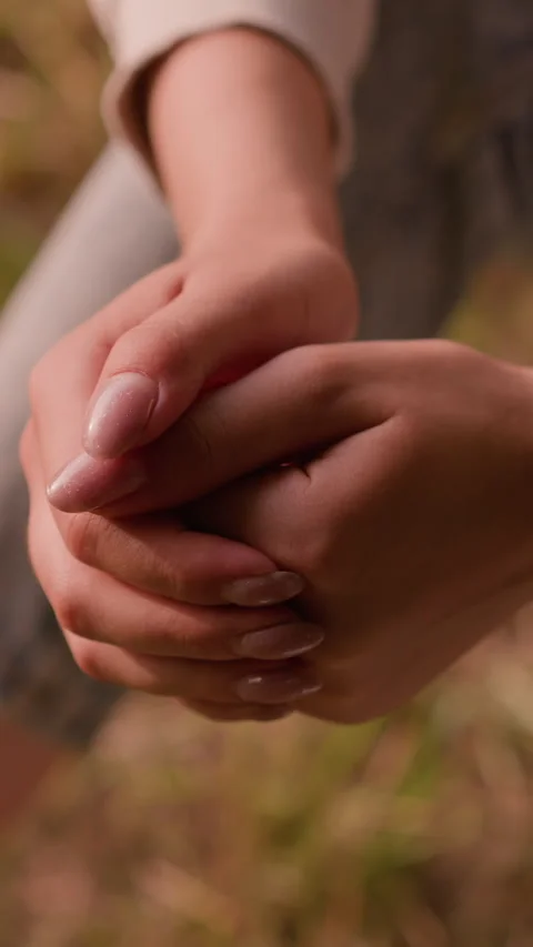 Close-Up of Clasped Hands in Reflective Pose with Soft Autumn Foliage Background 스톡 동영상 310412497