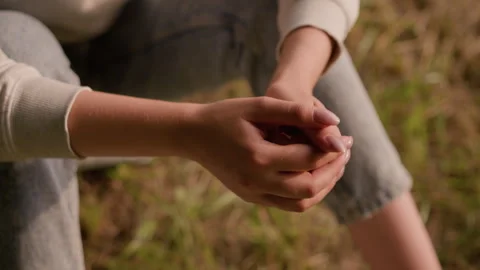 Close-Up of Clasping Hands in Reflective Pose with Soft Autumn Foliage 스톡 동영상 293655092