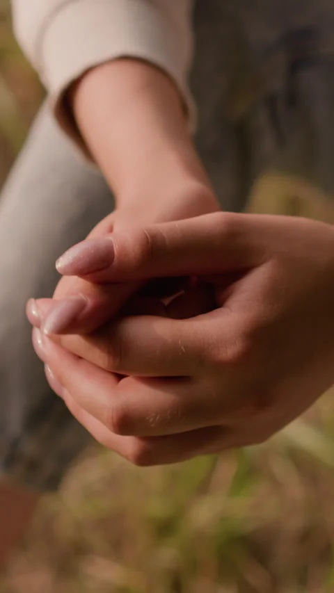 Close-Up of Clasping Hands in Reflective Pose with Soft Autumn Foliage 스톡 동영상 310412505