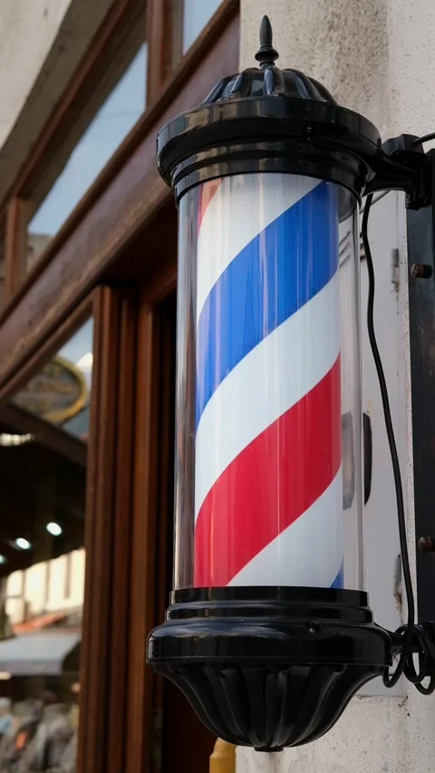 Close-up of a classic barber pole mounted outside a traditional barbershop Stock Footage 346690052