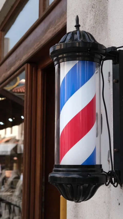 Close-up of a classic barber pole mounted outside a traditional barbershop Stock Footage 346690249
