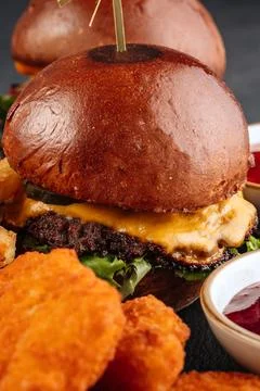 Close-up of a classic beef cheeseburger with melted cheese. Stock Photos