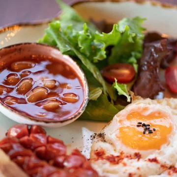 Close up of classic breakfast. Selective focus on beans in tomato sauce. Plate Stock Photos