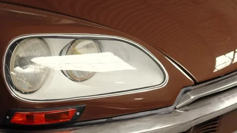 Close-up of classic car headlight with brown painted body reflecting light Video stock 308159973