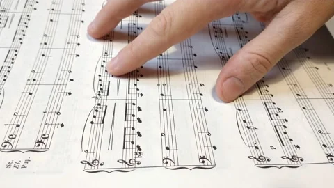 Close-up classical music notes. man's hand study classic music notes on paper. Stock Footage 224326613