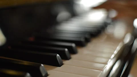 Close-up classical piano keyboard with a blurred pianist performing music. 스톡 동영상 221334066