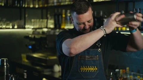 Close-up of a classy bartender making an alcoholic cocktail in a shaker. Stock Footage 236381516