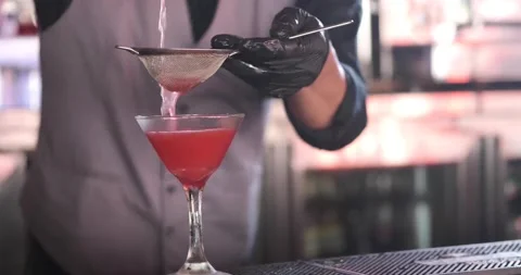 Close up of classy expert bartender making and serving red color cocktail with 스톡 동영상 156797032