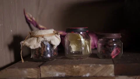 Close-up of a clay pot and small jars on an antique table in a wooden hut. Stock Footage 287583822