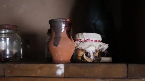 Close-up of a clay pot and small jars on an antique table in a wooden hut. Stock Footage 310655302