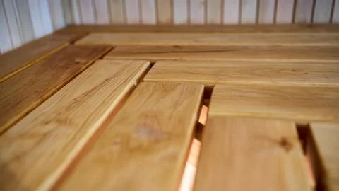 Close-up of clean herringbone pattern layout on alder sauna bench surface wit Stock Photos