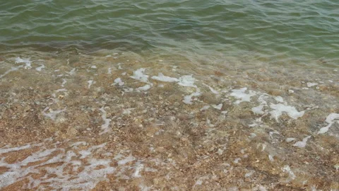 Close up of clean sea waves breaking on sandy beach Stock Footage 157478630