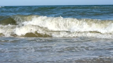 Close up of clean sea waves breaking on sandy beach with Sunset or sunrise light Video stock 158316802