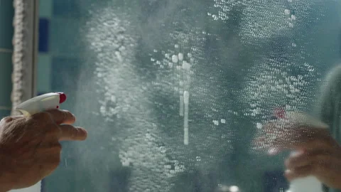 Close-up cleaning bathroom mirror Stockbeeldmateriaal 286933596