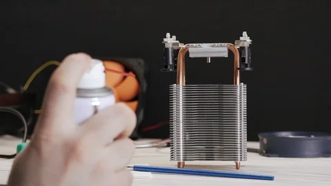 Close-up cleaning of computer's CPU cooling radiator. A service worker removes 库存影片 105072974