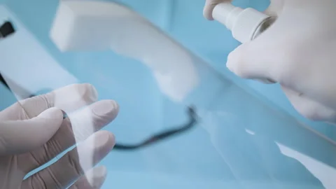 Close up of cleaning of a coronavirus face shield. Video stock 130331606