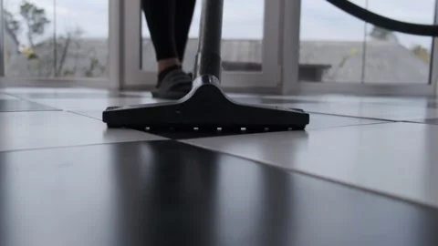 Close-Up Cleaning Floor with Vacuum on Black and White Tiles Stock Footage 295929905