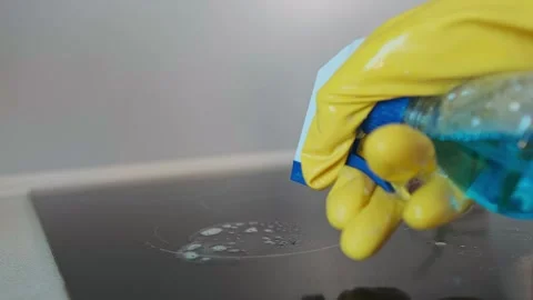Close up of a cleaning spray bottle as a hand sprays cleaning solution onto an e Stock Footage 301868882