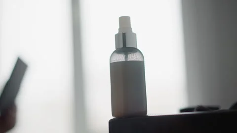 Close up of clear bottle with white liquid on black surface soft light indoor Stock Footage 347979929
