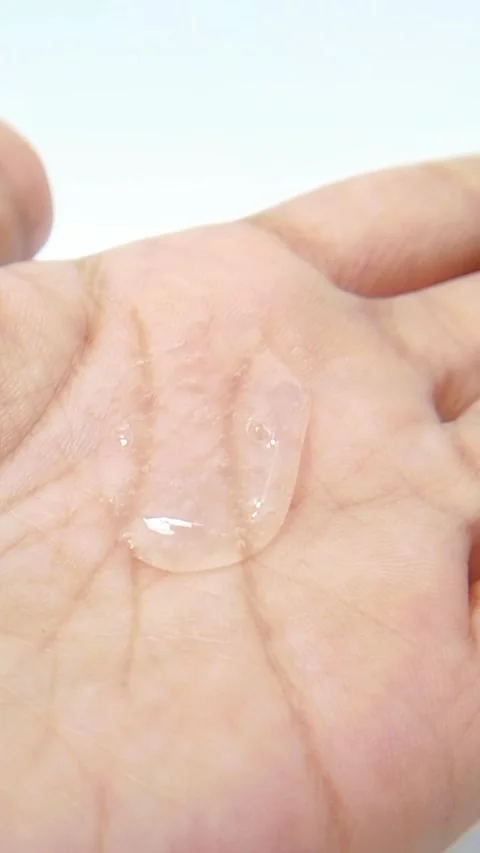 Close up of clear gel liquid on palm of hand. White background. Skin rejuve.. Vídeos de archivo 335022460