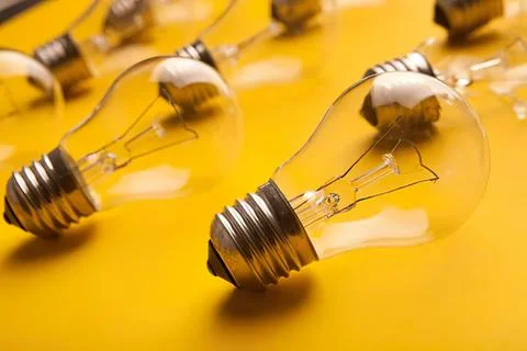 Close-up of clear light bulbs on yellow background Stock Photos