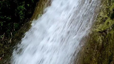 Close up of a clear mountain waterfall flowing through solid rock Stock Footage 321325528