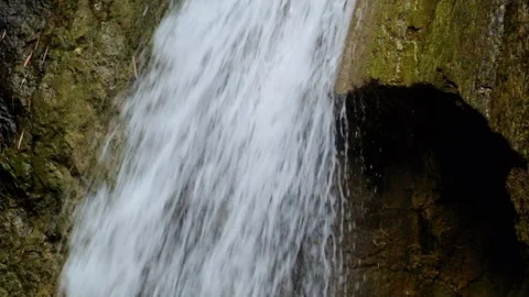 Close up of a clear mountain waterfall flowing through solid rock Stock Footage 321325529