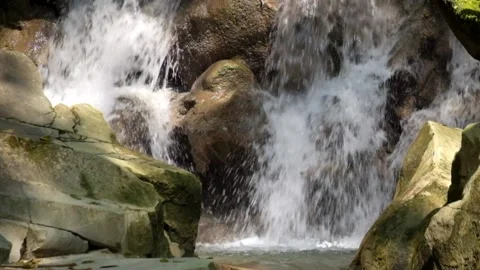 Close up of a clear mountain waterfall flowing through solid rock Stock Footage 321325547