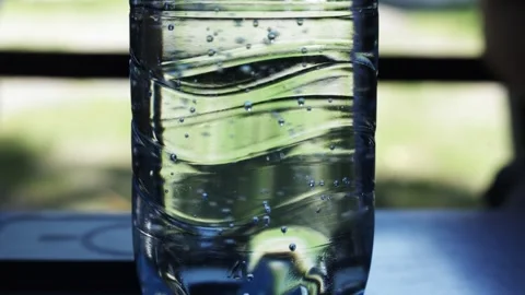 Close up of a clear plastic bottle filled with bubbly water outdoors Stock Footage 340263771