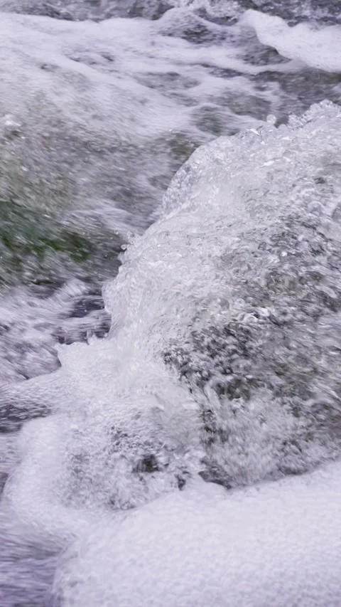 Close-up of clear shallow stream water rushing over rocks and waves Stock Footage 340485874
