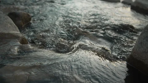 Close up of clear stream water flowing gently over smooth river rocks Stock Footage 341858101