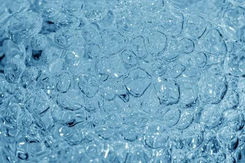 Close up of clear water bubbles in light blue color. Stock Photos