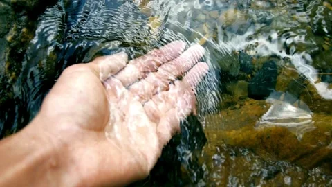 Close up, Clear water in a mountain river. slow motion man hiker taking fresh Stock Footage 270319675